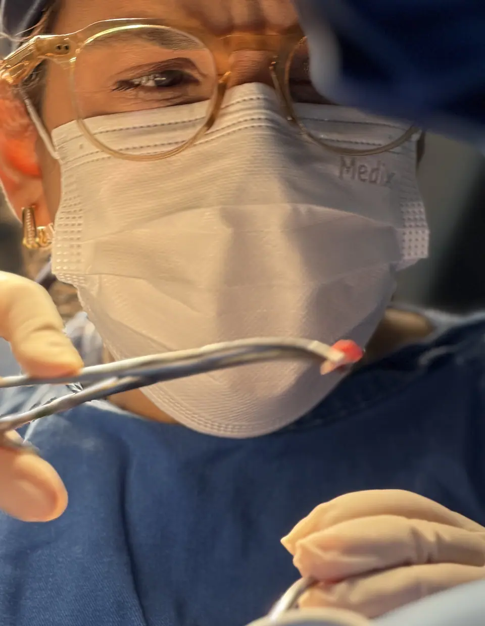 Dra. Gabriela Madeira de máscara e óculos durante uma cirurgia